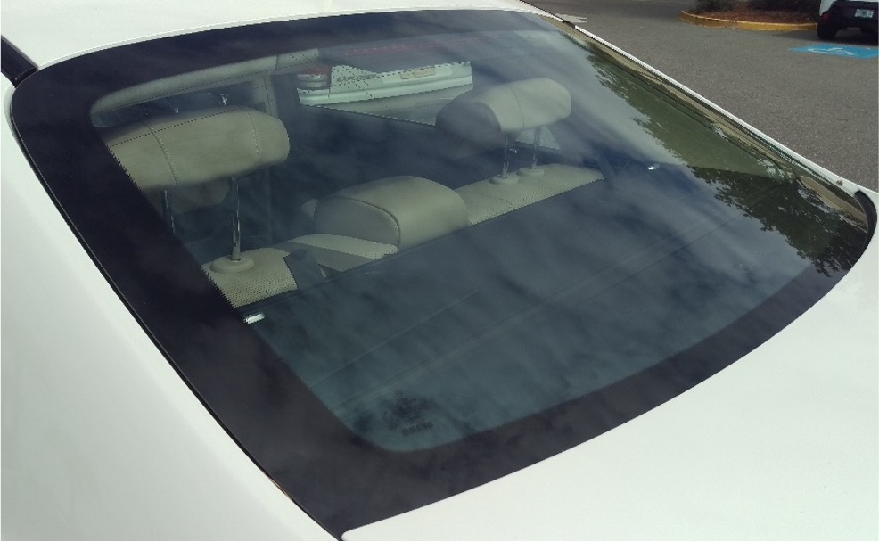 A photo of a car back window with glass heating element.