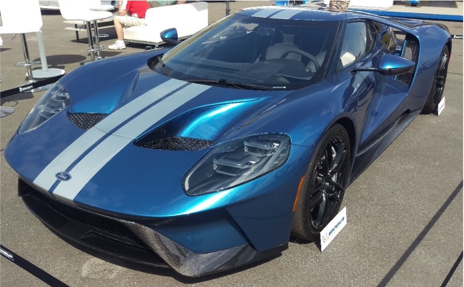 A photo of a blue sports car with a windshield glass antenna wire.