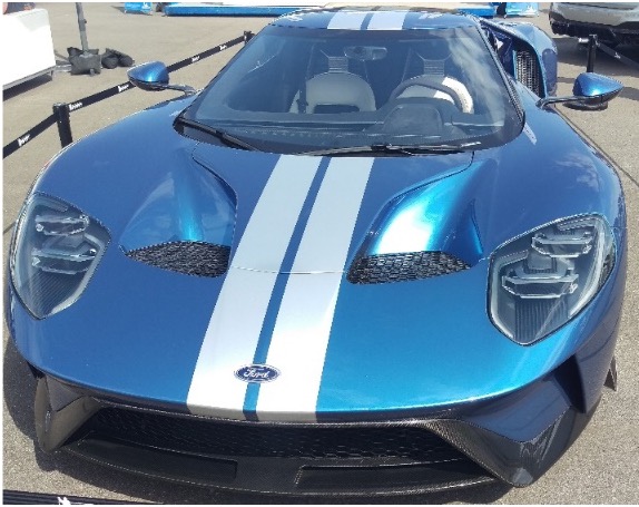 A photo of a blue sports car with a windshield glass antenna wire.